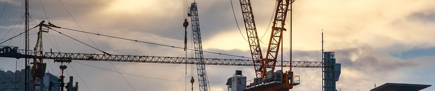 Construction cranes at dusk